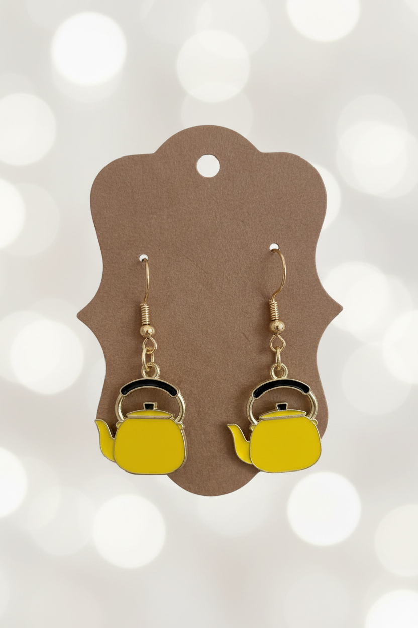 Teapot-shaped earrings on a brown card with a white background