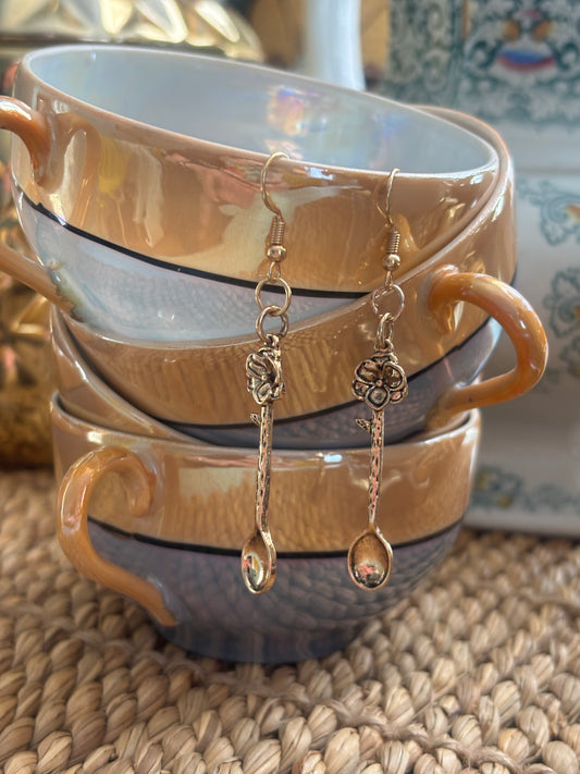 Gold earrings with a flower design on a teaspoon.