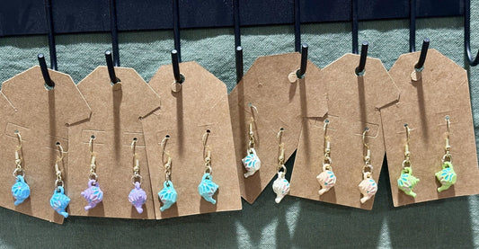 Patrick and Penn miniature teapot dangle earrings in various pastel colors with gold-tone hooks on display cards.